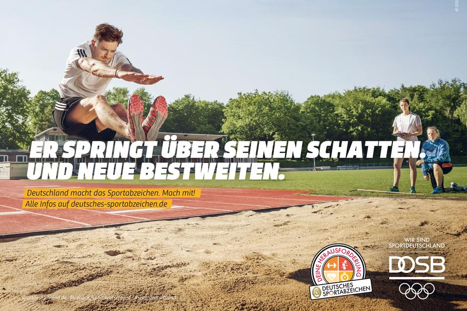 Weitspringer in der Luft über Sandgrube; Schrift: „Er springt über seinen Schatten. Und neue Bestweiten.“